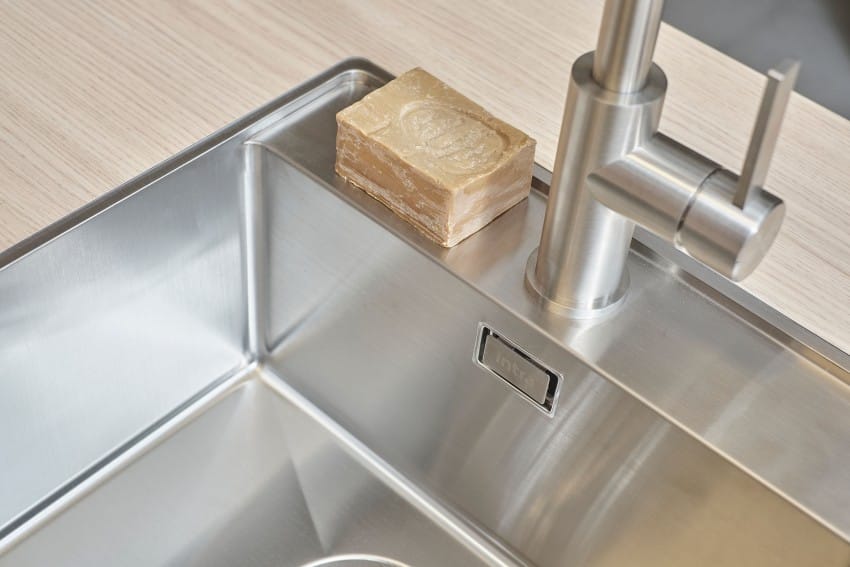 Vask i rustfritt stål med sølvkran og et såpestykke på benken. Foto: Nathan Lediard, Lediard Foto AS.