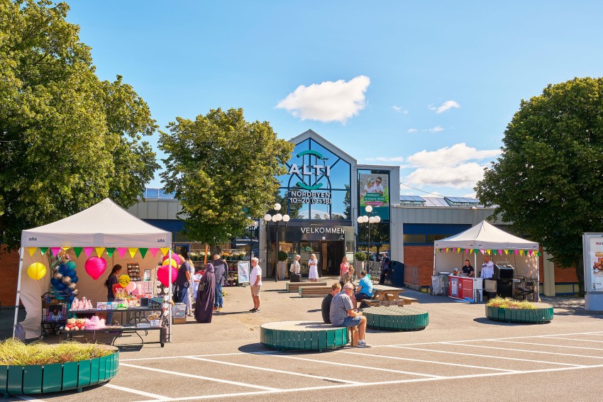 Folk samles utenfor en bygning med telt, dekorasjoner og et "Velkommen"-skilt under klar himmel. Foto: Nathan Lediard, Lediard Foto AS.
