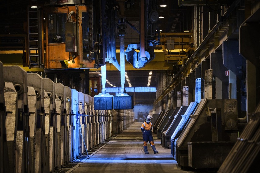 Arbeider i verneutstyr står i en industrifabrikk med maskineri og overlys. Foto: Nathan Lediard, Lediard Foto AS.