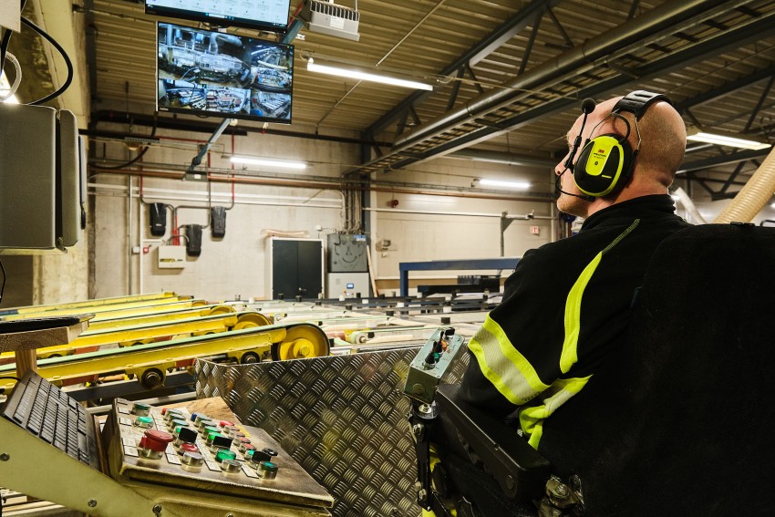 Person i sikkerhetsutstyr betjener maskiner, overvåker skjermer i industrielle omgivelser. Foto: Nathan Lediard, Lediard Foto AS.