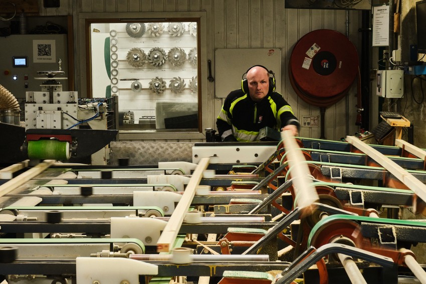 Arbeider på en fabrikk med hodetelefoner, som betjener store maskiner med gir og rør i industrielle omgivelser. Foto: Nathan Lediard, Lediard Foto AS.