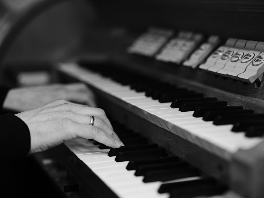 Nærbilde av hender som spiller et tastaturinstrument, med fokus på tangenter og fingre, i svart og hvitt. Foto: Nathan Lediard, Lediard Foto AS.