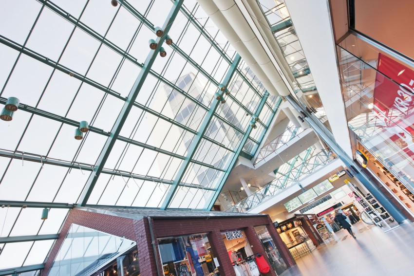 Kjøpesenterinteriør med høye glasstak, butikker og moderne arkitektur. Foto: Nathan Lediard, Lediard Foto AS.