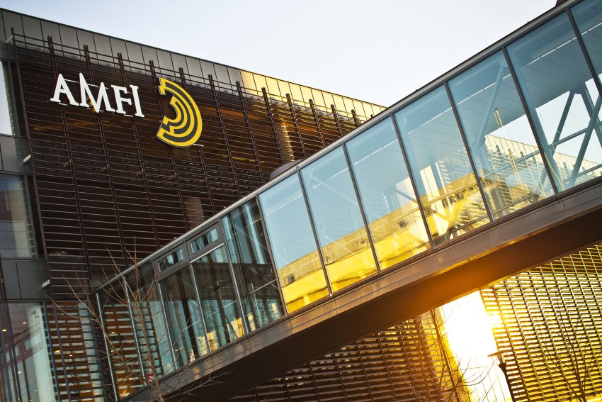 Glassgang og bygning med AMFI-logo ved solnedgang. Foto: Nathan Lediard, Lediard Foto AS.